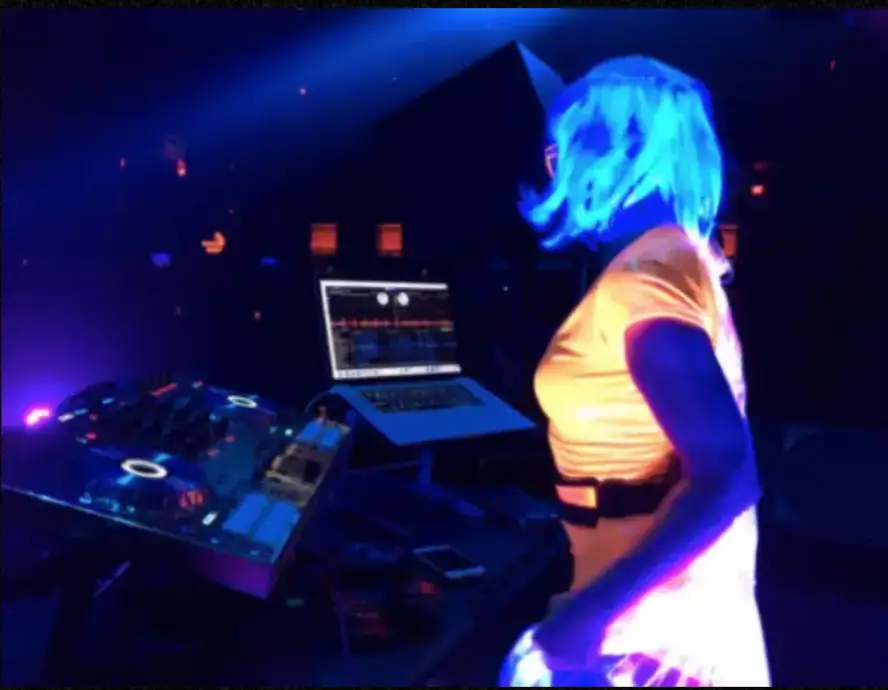 DeeJay Shelly performing her Glow Show at Mandalay Bay Las Vegas, glowing behind her Pioneer controller and MacBook – female DJ and event entertainment