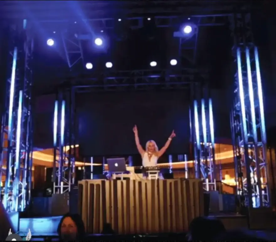 DeeJay Shelly performing at Harrah’s Pool After Dark in Atlantic City with her hand raised – female DJ and nightlife entertainment