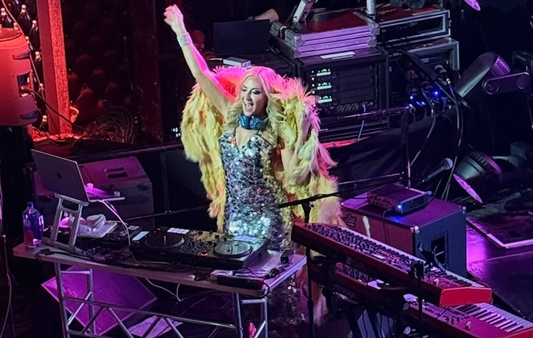 Corporate Event Entertainment Ideas - DeeJay Shelly performing live at the Edison Ballroom in Times Square NYC wearing Gold Wings with hand raised over the DJ Booth