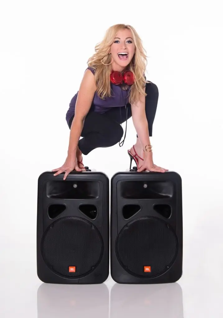 DeeJay Shelly, a female DJ in Philadelphia, standing on speakers wearing red headphones